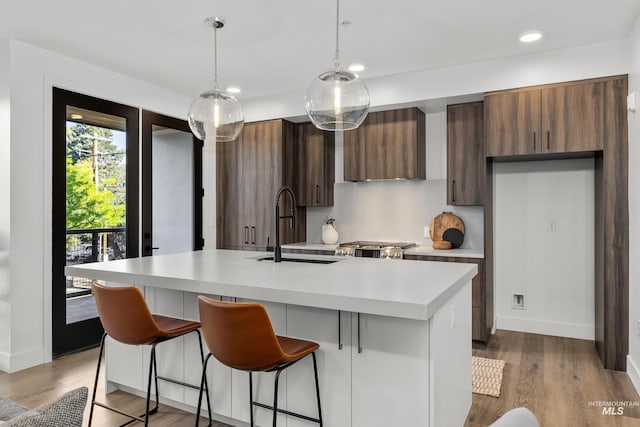 1620 W Bannock St # 303, Boise, ID 83702 - kitchen featuring a sink, light countertops, wood finished floors, a center island with sink, and modern cabinets
