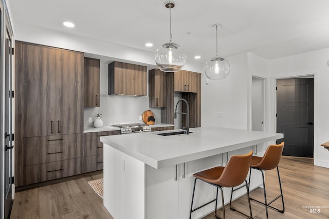 1620 W Bannock St # 303, Boise, ID 83702 - kitchen with a sink, modern cabinets, light countertops, light wood-style flooring, and a breakfast bar area