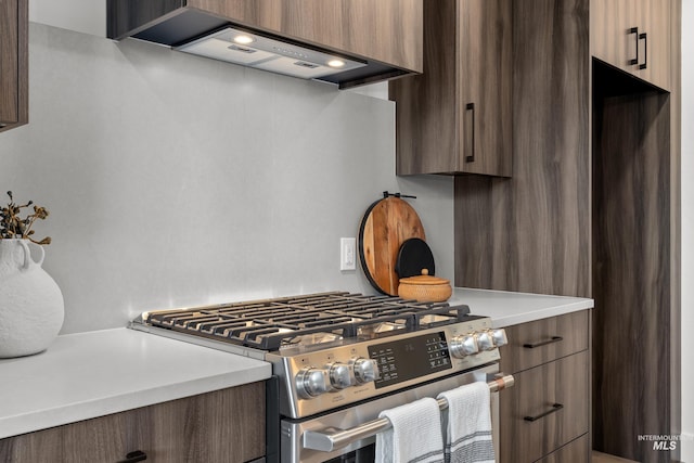 1620 W Bannock St # 303, Boise, ID 83702 - kitchen featuring stainless steel gas range, light countertops, wall chimney range hood, and modern cabinets