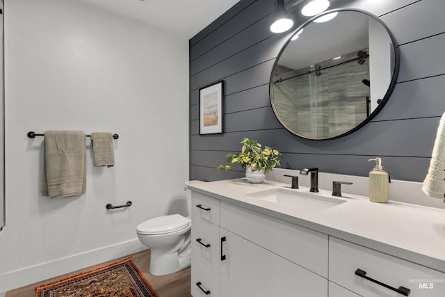 1620 W Bannock St # 303, Boise, ID 83702 - bathroom featuring vanity, a stall shower, wood finished floors, toilet, and baseboards
