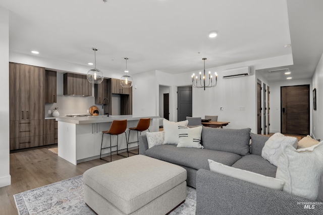 1620 W Bannock St # 303, Boise, ID 83702 - living room featuring a wall unit AC, a chandelier, recessed lighting, and light wood-style flooring