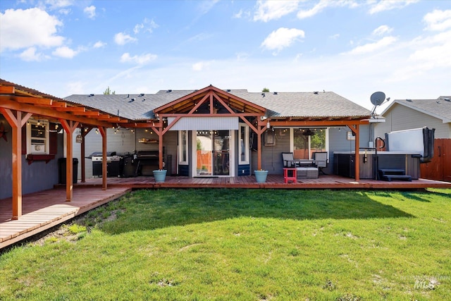 back of property featuring a hot tub, a wooden deck, and a yard