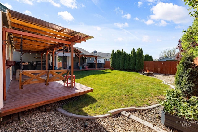 view of yard with a fenced backyard, an outdoor fire pit, and a deck