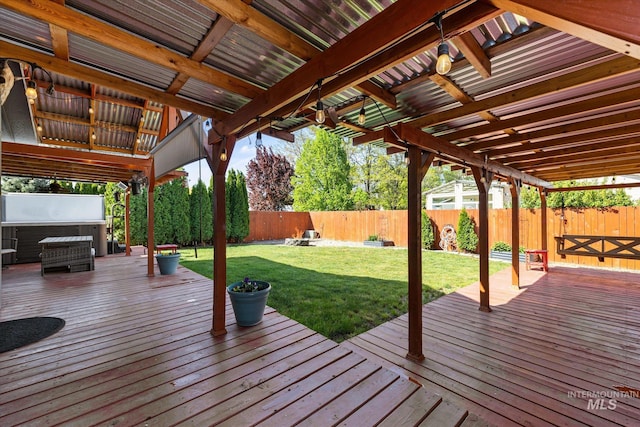 wooden terrace featuring a fenced backyard, a hot tub, and a lawn