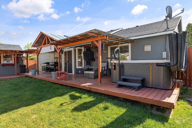 rear view of house with fence, a yard, a hot tub, and a deck