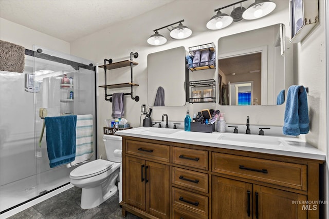 full bathroom with double vanity, toilet, a shower stall, and a sink