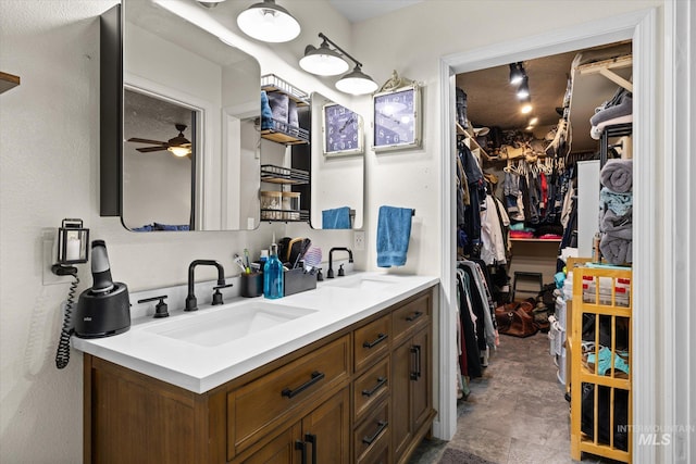 bathroom featuring a sink, a walk in closet, and double vanity