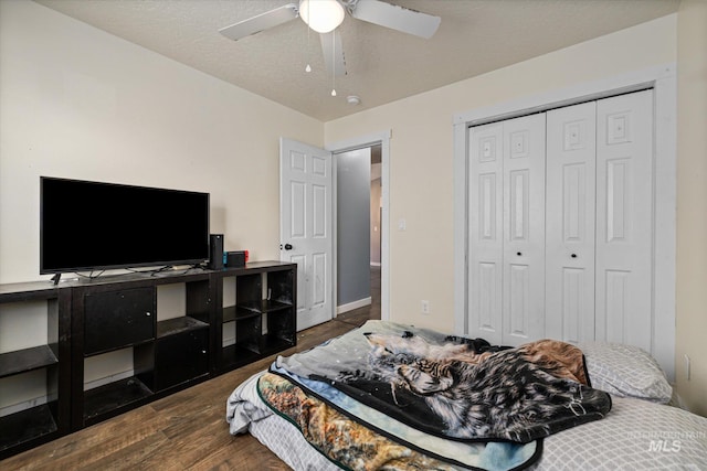 bedroom featuring a ceiling fan, dark wood-style floors, and a closet