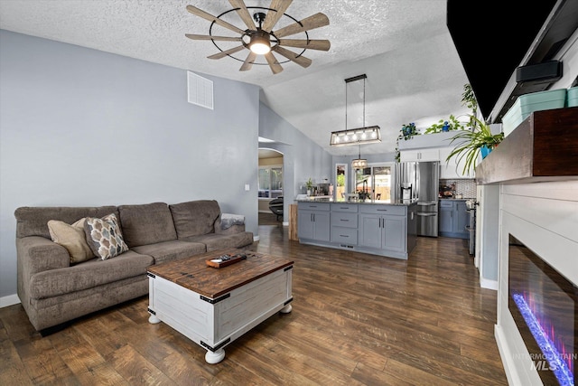 living room with ceiling fan, visible vents, arched walkways, lofted ceiling, and dark wood-type flooring