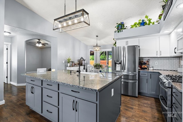 kitchen featuring decorative backsplash, ceiling fan, appliances with stainless steel finishes, a sink, and gray cabinetry