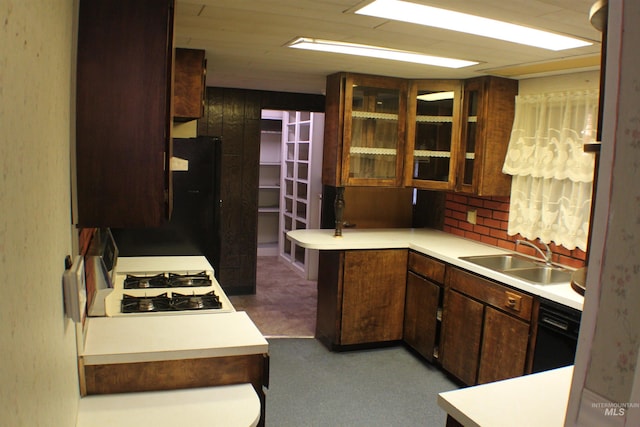 kitchen featuring black fridge, sink, stove, and dark brown cabinets