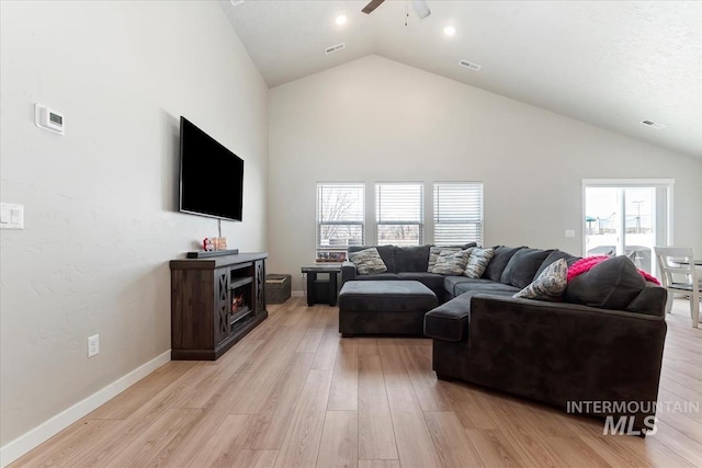 living room with ceiling fan, high vaulted ceiling, and light hardwood / wood-style flooring