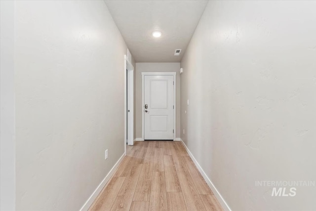 corridor with light hardwood / wood-style floors