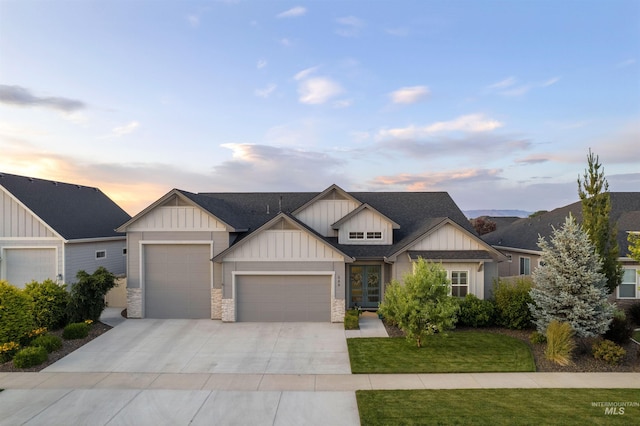 540 E Andes Dr, Kuna, ID 83634 - view of front of home with board and batten siding, an attached garage, driveway, a lawn, and a shingled roof
