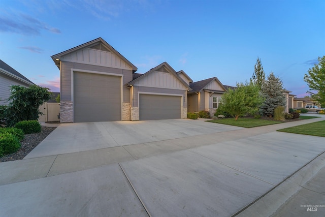 540 E Andes Dr, Kuna, ID 83634 - view of front of house with board and batten siding, a garage, driveway, and stone siding