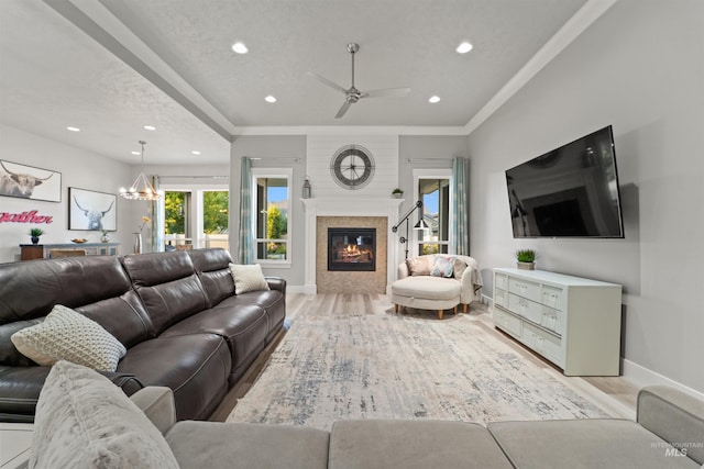540 E Andes Dr, Kuna, ID 83634 - living area with light wood-style floors, recessed lighting, a ceiling fan, a glass covered fireplace, and ornamental molding