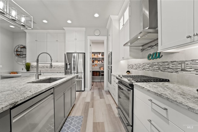540 E Andes Dr, Kuna, ID 83634 - kitchen featuring wall chimney range hood, stainless steel appliances, light wood-type flooring, backsplash, and recessed lighting