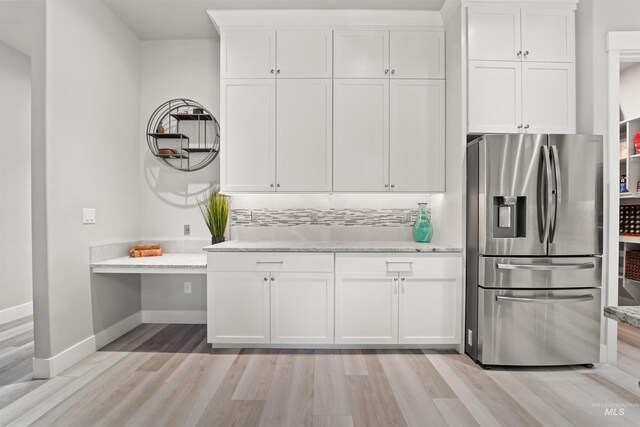 540 E Andes Dr, Kuna, ID 83634 - kitchen with stainless steel fridge, light wood-type flooring, white cabinetry, light stone counters, and tasteful backsplash