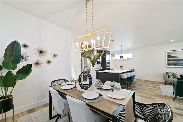 dining space with light wood-type flooring and an inviting chandelier