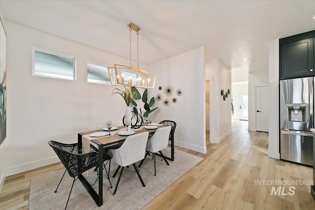 dining room with a chandelier and light wood-type flooring