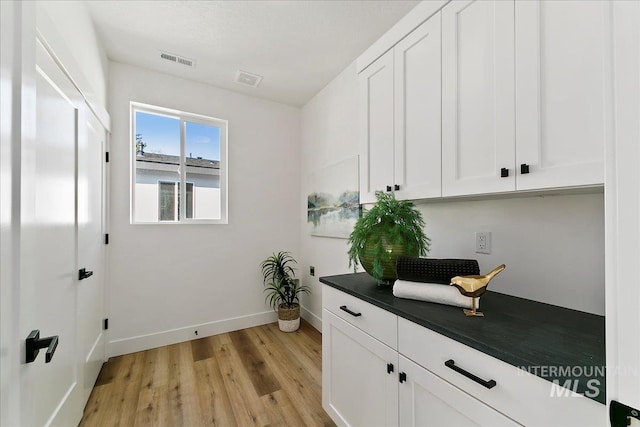 interior space featuring cabinets, light hardwood / wood-style flooring, and hookup for an electric dryer