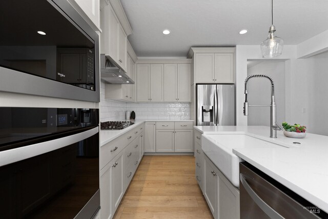 8333 S Updale Ave, Meridian, ID 83642 - kitchen with white cabinets, light countertops, a sink, pendant lighting, and appliances with stainless steel finishes