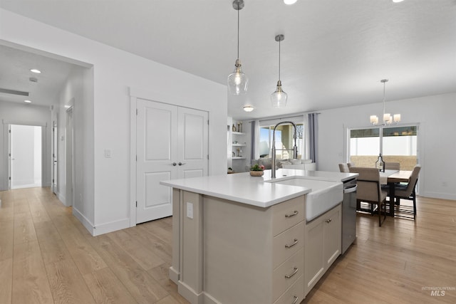 8333 S Updale Ave, Meridian, ID 83642 - kitchen with stainless steel dishwasher, a sink, light wood-type flooring, a notable chandelier, and light countertops