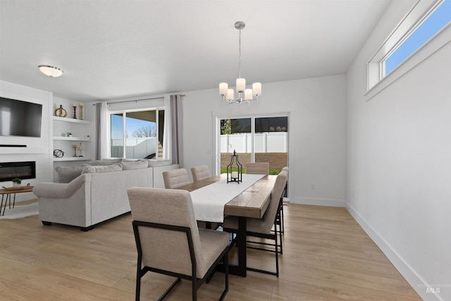 8333 S Updale Ave, Meridian, ID 83642 - dining space with an inviting chandelier, light wood-style floors, baseboards, a fireplace, and built in shelves