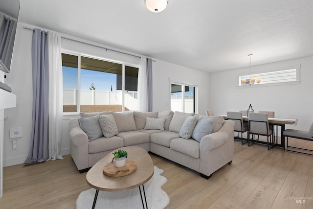 8333 S Updale Ave, Meridian, ID 83642 - living area featuring light wood-style flooring, a wealth of natural light, and a notable chandelier