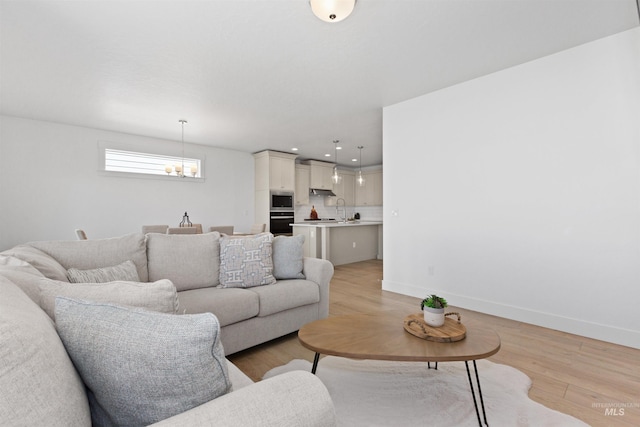 8333 S Updale Ave, Meridian, ID 83642 - living area with a chandelier, baseboards, and light wood-style floors