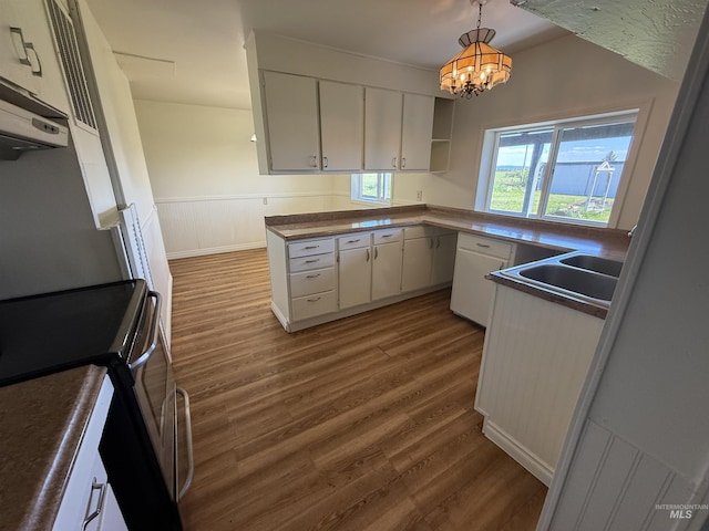 5656 Three Mile Rd, Weippe, ID 83553 - kitchen with stainless steel range with electric cooktop, dark wood-style flooring, a sink, dark countertops, and a chandelier