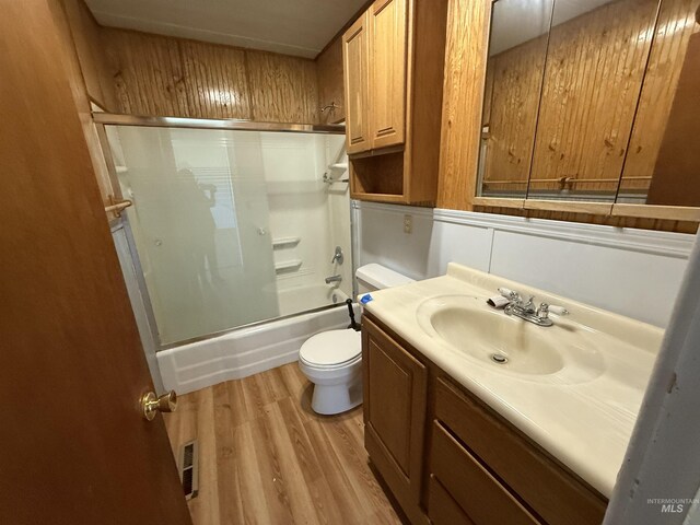 5656 Three Mile Rd, Weippe, ID 83553 - bathroom featuring toilet, wood finished floors, vanity, and bath / shower combo with glass door