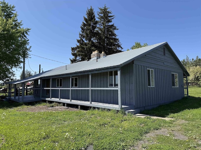 5656 Three Mile Rd, Weippe, ID 83553 - view of side of home with board and batten siding, a lawn, a chimney, and metal roof