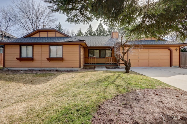 view of front of property featuring driveway, roof with shingles, a front yard, an attached garage, and a chimney