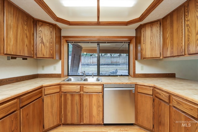 kitchen with a sink, dishwasher, tile counters, and brown cabinetry