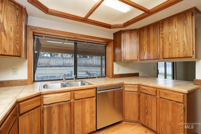 kitchen featuring a sink, brown cabinets, dishwasher, and tile counters