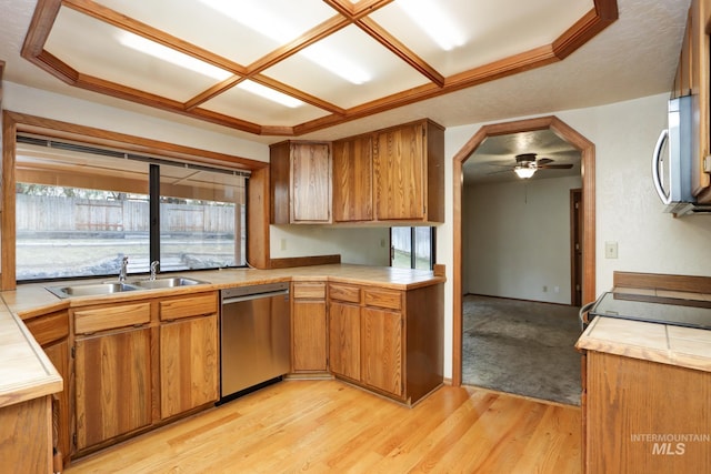 kitchen with a sink, light countertops, brown cabinets, and stainless steel appliances