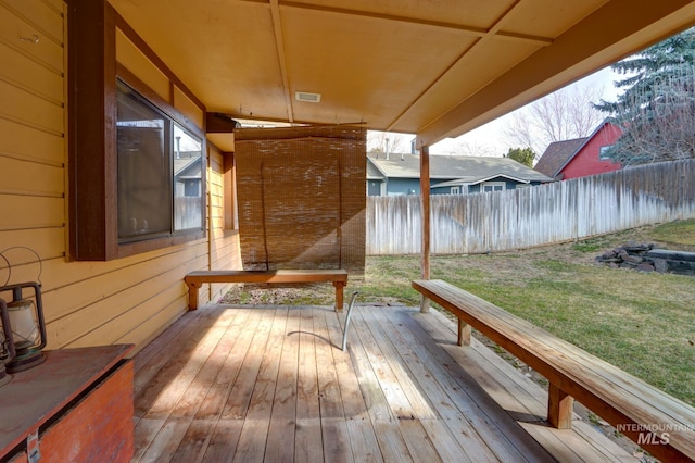 wooden terrace with a lawn and fence