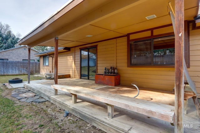 wooden terrace featuring fence and visible vents