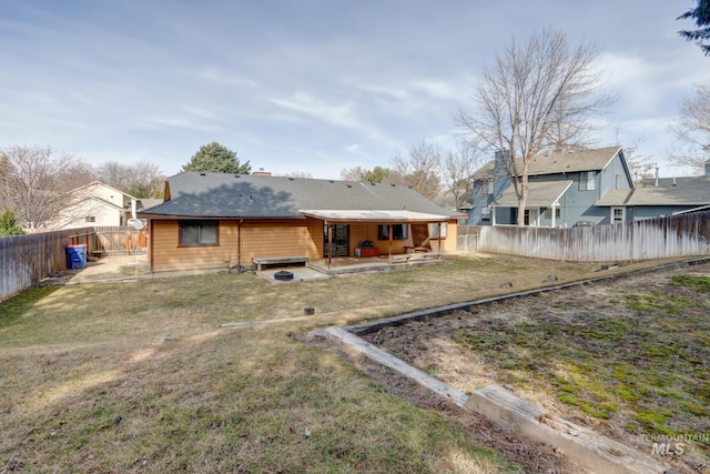 rear view of house with a patio, a yard, and a fenced backyard