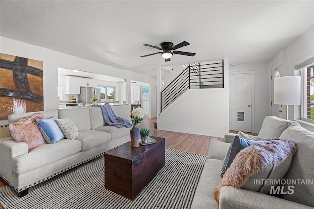 living room with light hardwood / wood-style floors, ceiling fan, and plenty of natural light