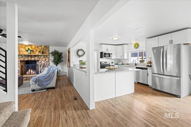 kitchen featuring white cabinetry, appliances with stainless steel finishes, and light hardwood / wood-style flooring