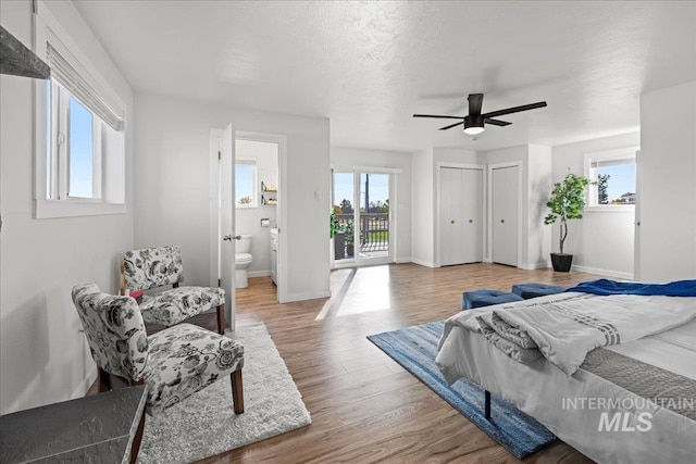bedroom featuring ensuite bathroom, ceiling fan, a textured ceiling, access to exterior, and hardwood / wood-style floors