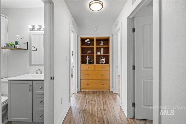 hallway with light hardwood / wood-style floors and sink
