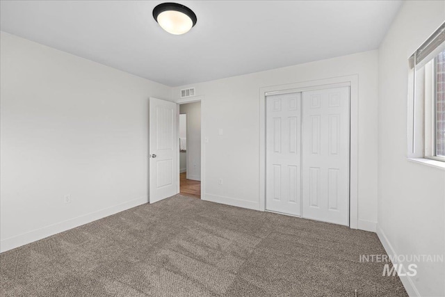 unfurnished bedroom with carpet floors and a closet