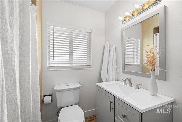 bathroom featuring toilet, vanity, and hardwood / wood-style floors