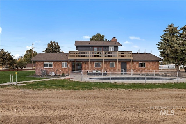 view of front of home featuring a patio, cooling unit, and a front yard