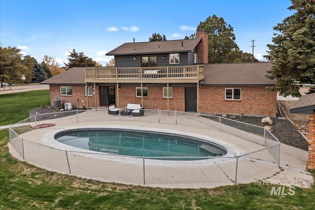 view of pool featuring a patio area, central AC, and a yard