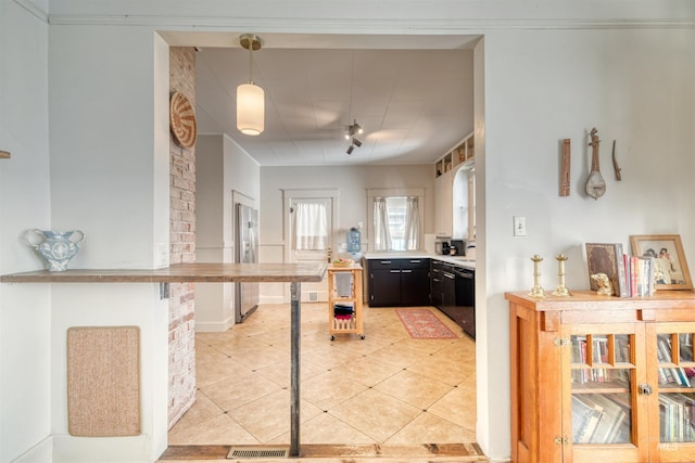 kitchen featuring stainless steel fridge with ice dispenser, light countertops, light tile patterned floors, dishwasher, and hanging light fixtures