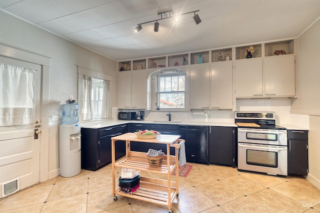 kitchen featuring blue cabinetry, double oven range, dishwasher, and light countertops